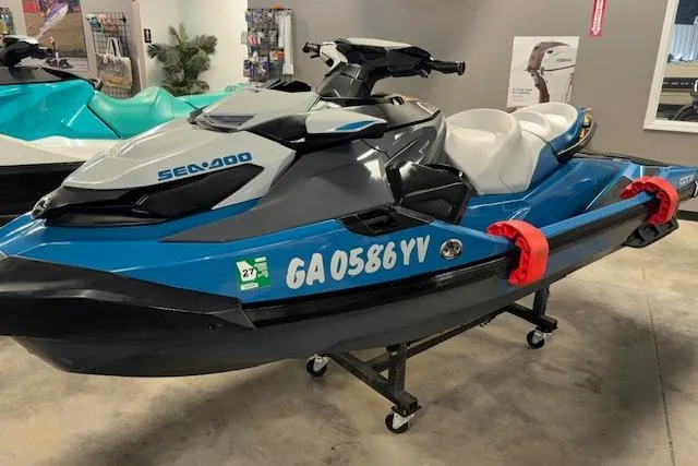Slide: The Image of 2018 Sea-Doo GTX 155 jet ski in showroom, blue and gray design, displayed on stand. - 20