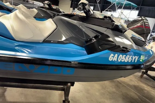 Slide: The Image of 2018 Sea-Doo GTX 155 jet ski in showroom, blue and gray design. - 3