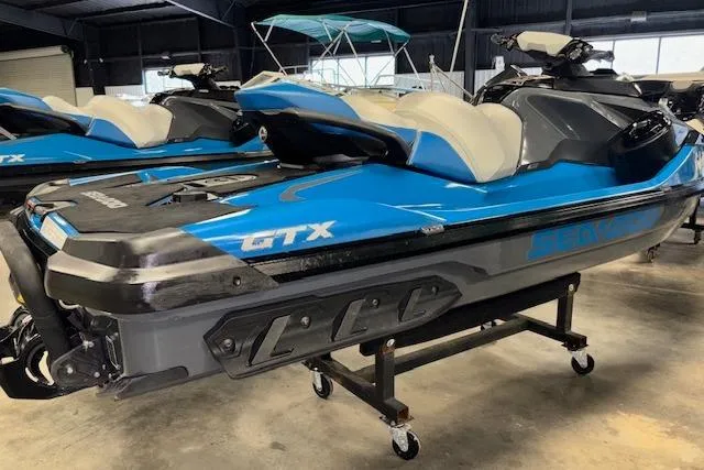 Slide: The Image of 2018 Sea-Doo GTX 155 jet ski in showroom, blue and black design. - 4