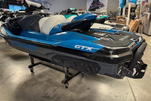 Slide: The Image of 2018 Sea-Doo GTX 155 jet ski in showroom, blue and black design. - 9