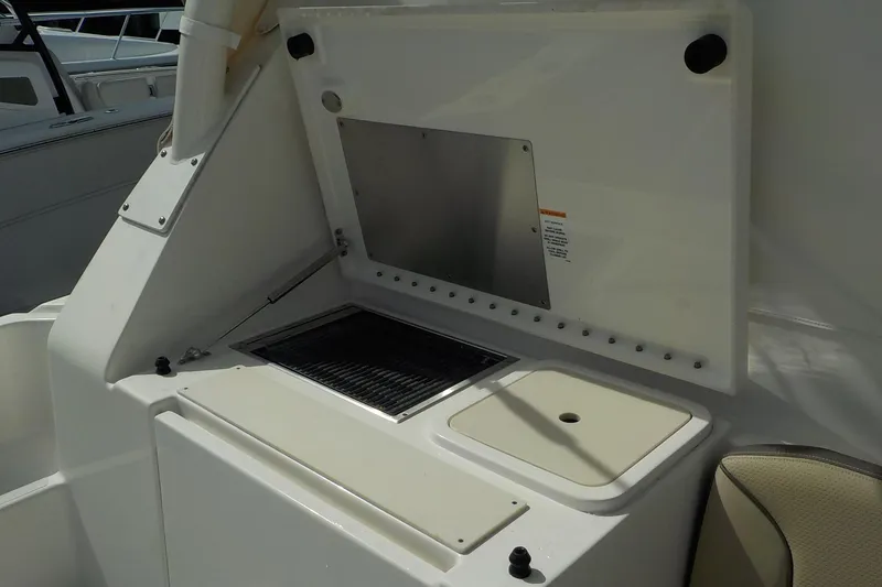 Slide: The Image of 2020 Pursuit OS 355 Offshore boat interior with built-in grill and storage compartment. - 16