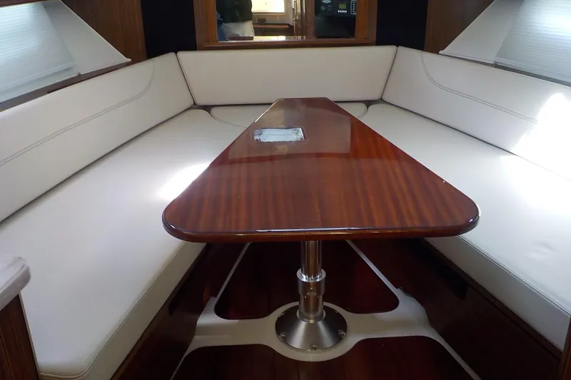 Slide: The Image of 2020 Pursuit OS 355 Offshore interior with elegant wooden table and cushioned seating. - 20