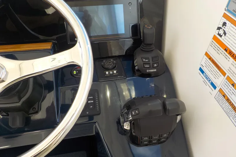 Slide: The Image of 2020 Pursuit OS 355 Offshore helm with steering wheel, Yamaha controls, and warning labels. - 6