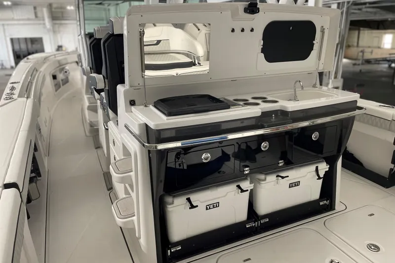 Slide: The Image of 2025 Blackfin 400 CC boat interior with kitchenette and Yeti coolers. - 11
