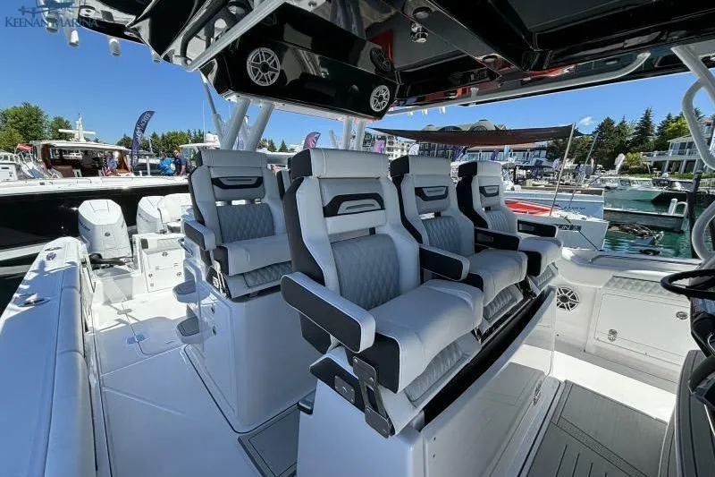 Slide: The Image of 2025 Blackfin 400 CC boat interior with luxurious seating at a marina. - 16
