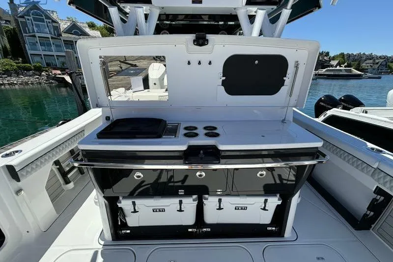 Slide: The Image of 2025 Blackfin 400 CC boat with outdoor kitchen setup, featuring grill and coolers. - 18