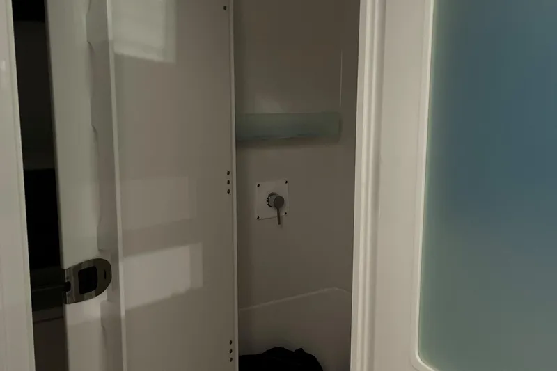 Slide: The Image of Interior of a 2025 Blackfin 400 CC boat, featuring a compact shower area. - 22