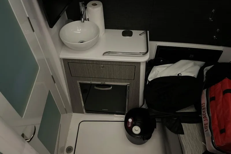 Slide: The Image of Interior of 2025 Blackfin 400 CC boat with sink, storage, and life jackets. - 24