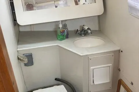 Slide: The Image of 1995 Catalina 30 Mk III boat bathroom with sink, mirror, and toiletries. - 14