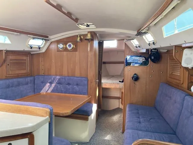 Slide: The Image of Interior of a 1995 Catalina 30 Mk III sailboat with blue seating and wooden accents. - 8