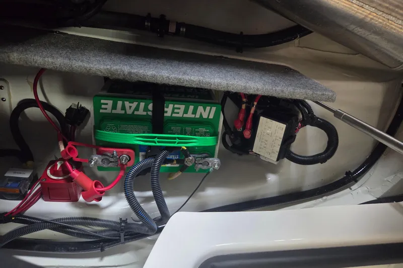 Slide: The Image of 2023 Scarab 165 H.O. Platinum boat battery compartment with Interstate battery and wiring. - 17