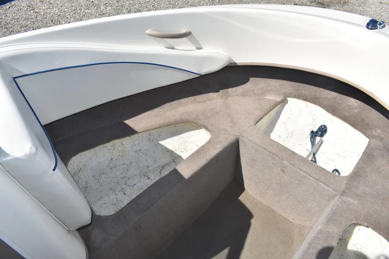 Slide: The Image of 2004 Bayliner 215 Bowrider interior with gray carpet and white seating. - 11