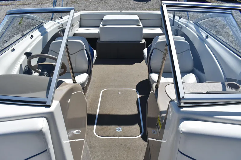 Slide: The Image of 2004 Bayliner 215 Bowrider interior with seating and steering wheel, showcasing spacious design. - 13