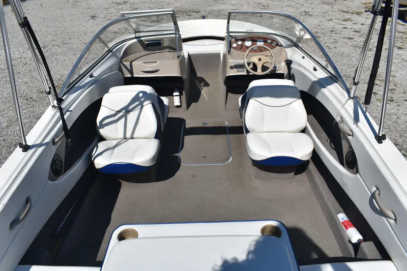 Slide: The Image of 2004 Bayliner 215 Bowrider interior with white seating and steering wheel. - 5