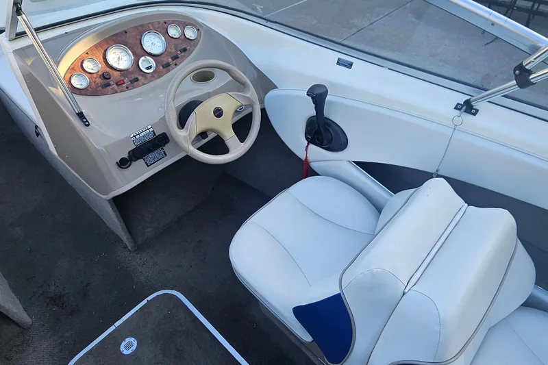 Slide: The Image of 2004 Bayliner 215 Bowrider interior with steering wheel and dashboard controls. - 6