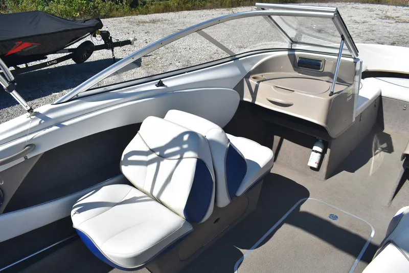 Slide: The Image of 2004 Bayliner 215 Bowrider interior with white seating and windshield. - 7