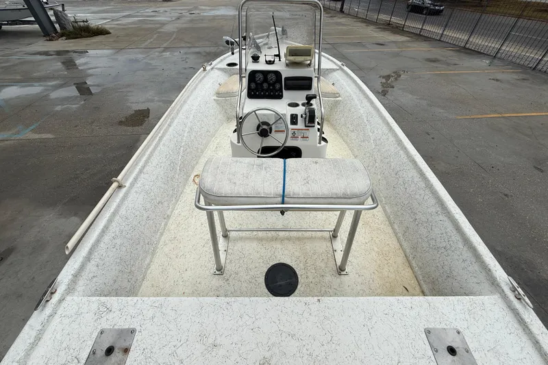 Slide: The Image of 2008 Mako 191 Inshore boat interior with steering console and seating, parked on wet pavement. - 8