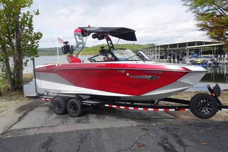 Slide: The Image of 2021 Nautique Super Air Nautique G23 boat on trailer by lakeside. - 0