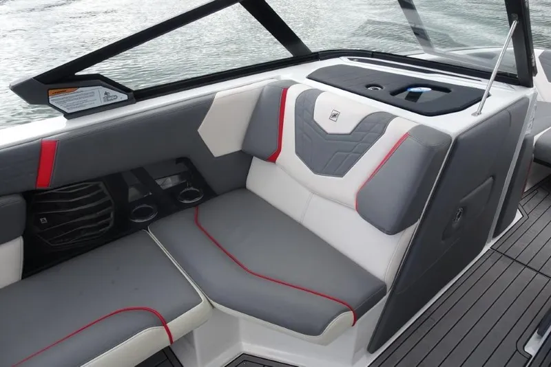 Slide: The Image of 2021 Nautique Super Air Nautique G23 interior with gray and red seating, cup holders, and sleek design. - 14