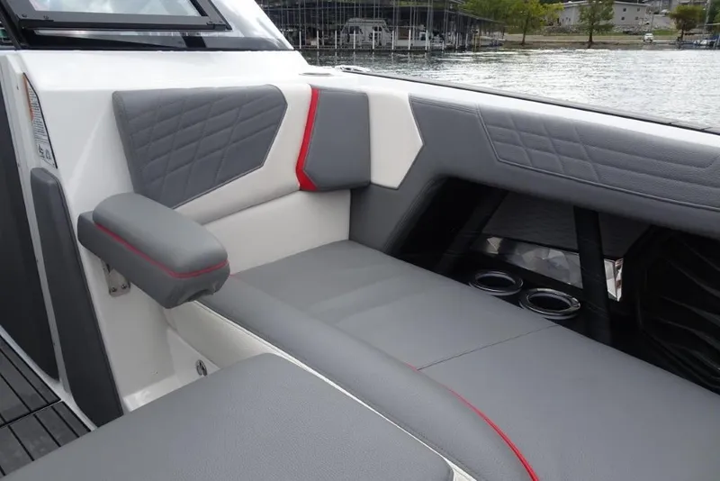 Slide: The Image of 2021 Nautique Super Air Nautique G23 interior with gray and red upholstery, lake view. - 17