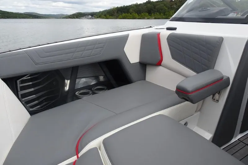 Slide: The Image of 2021 Nautique Super Air Nautique G23 interior with gray and red seating, cup holders, and speaker. - 18