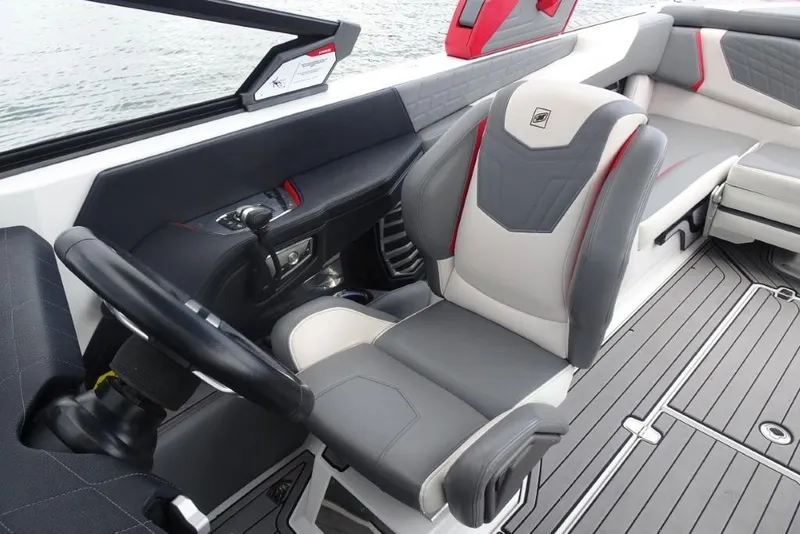 Slide: The Image of 2021 Nautique Super Air Nautique G23 interior with sleek captain's chair and modern dashboard. - 19