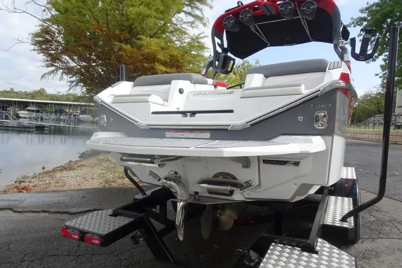 Slide: The Image of 2021 Nautique Super Air Nautique G23 boat on trailer by lakeside. - 2