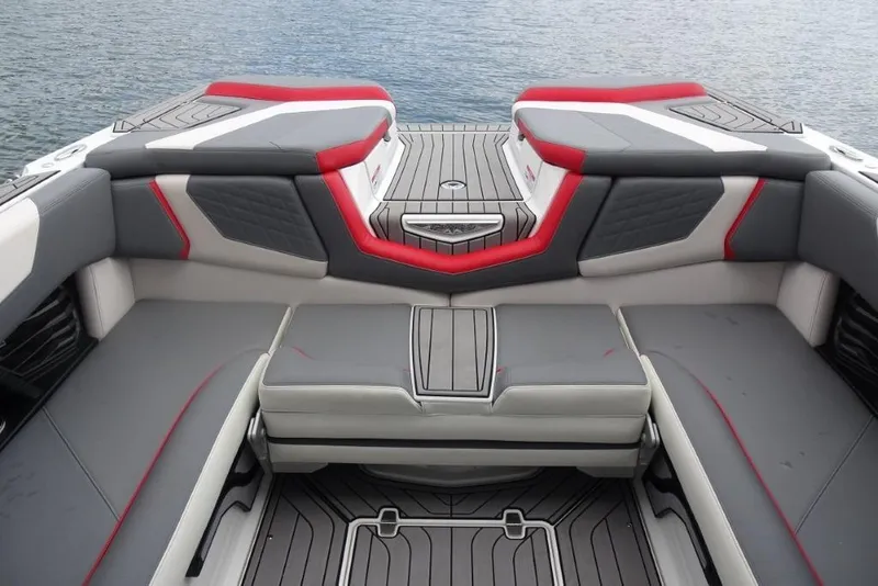 Slide: The Image of 2021 Nautique Super Air Nautique G23 interior with gray and red seating, on water. - 21