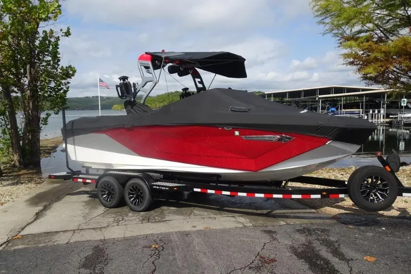 Slide: The Image of 2021 Nautique Super Air Nautique G23 boat on trailer by lakeside. - 25