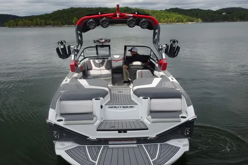 Slide: The Image of 2021 Nautique Super Air Nautique G23 boat on a calm lake, rear view. - 7