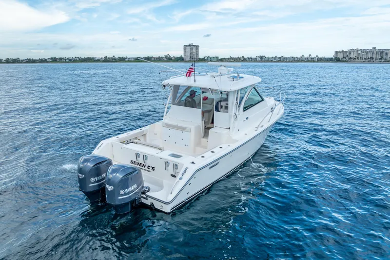 Slide: The Image of 2011 Pursuit OS 345 Offshore boat on open water with twin Yamaha engines. - 11