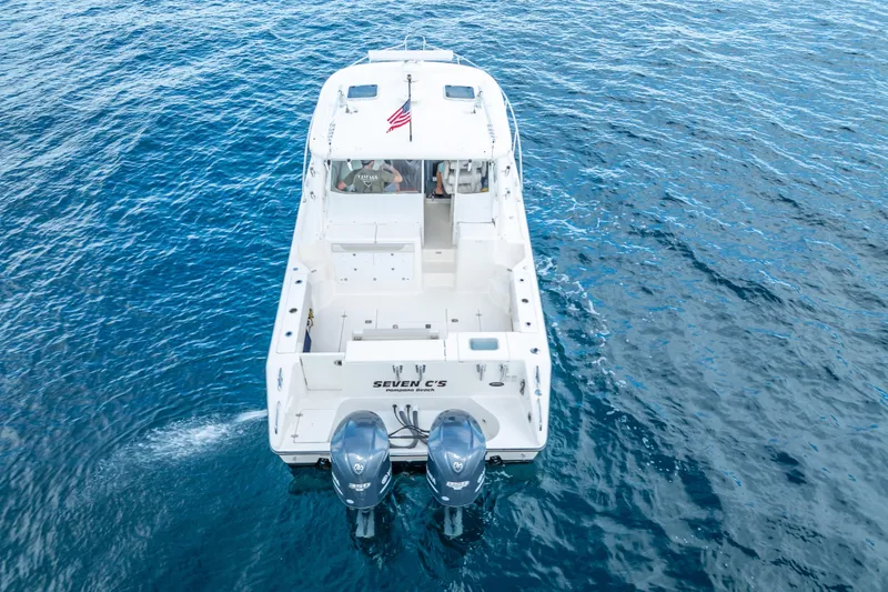 Slide: The Image of 2011 Pursuit OS 345 Offshore boat on open water, rear view with dual engines. - 12