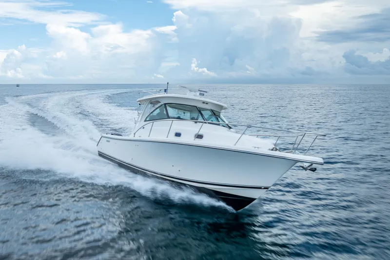 Slide: The Image of 2011 Pursuit OS 345 Offshore boat cruising on open ocean under cloudy sky. - 25