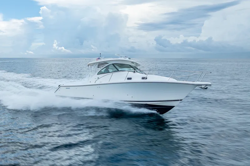 Slide: The Image of 2011 Pursuit OS 345 Offshore boat cruising on open water under cloudy skies. - 26