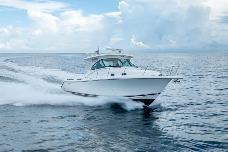 Slide: The Image of 2011 Pursuit OS 345 Offshore boat cruising on open water under a cloudy sky. - 27