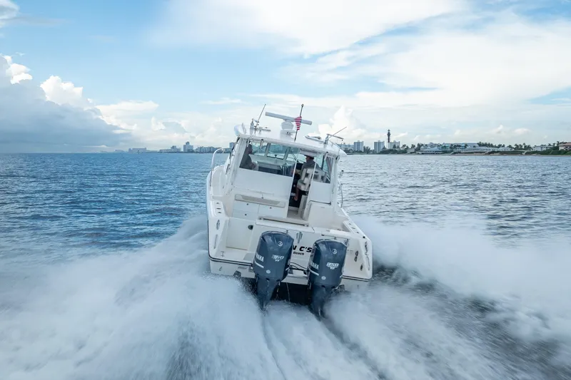 Slide: The Image of 2011 Pursuit OS 345 Offshore boat cruising on open water, rear view. - 28