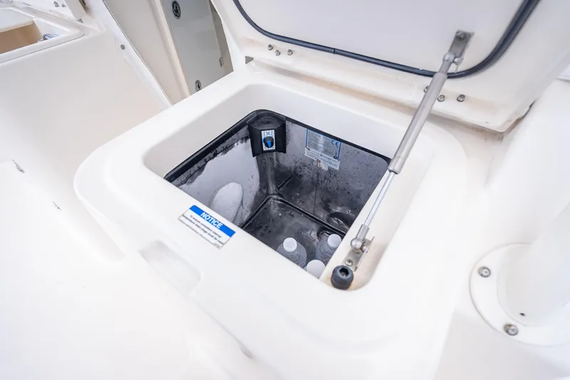 Slide: The Image of 2011 Pursuit OS 345 Offshore boat cooler compartment with open lid and stored bottles. - 42