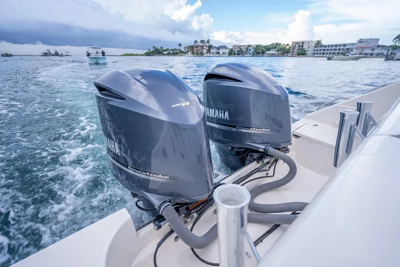 Slide: The Image of Twin Yamaha outboard engines on a 2011 Pursuit OS 345 Offshore boat cruising in coastal waters. - 44