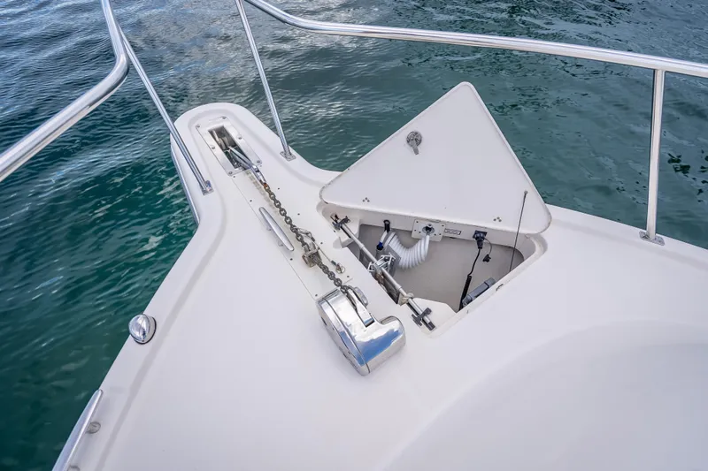Slide: The Image of 2011 Pursuit OS 345 Offshore boat anchor compartment with chain, on calm water. - 47