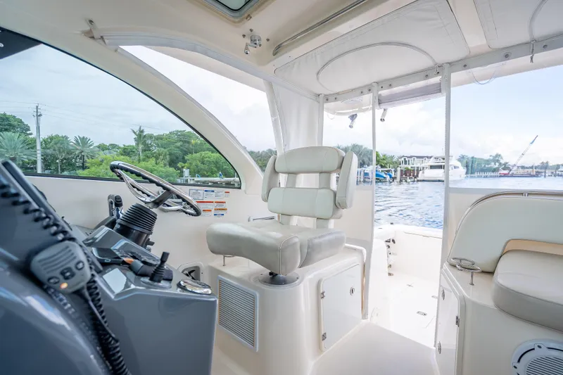 Slide: The Image of 2011 Pursuit OS 345 Offshore boat interior with helm and seating. - 49