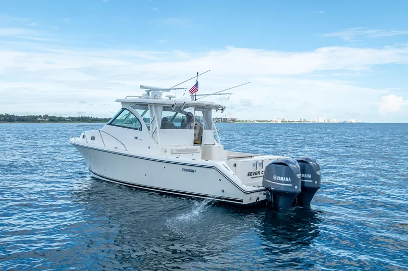 Slide: The Image of 2011 Pursuit OS 345 Offshore boat cruising on open water with twin Yamaha engines. - 5