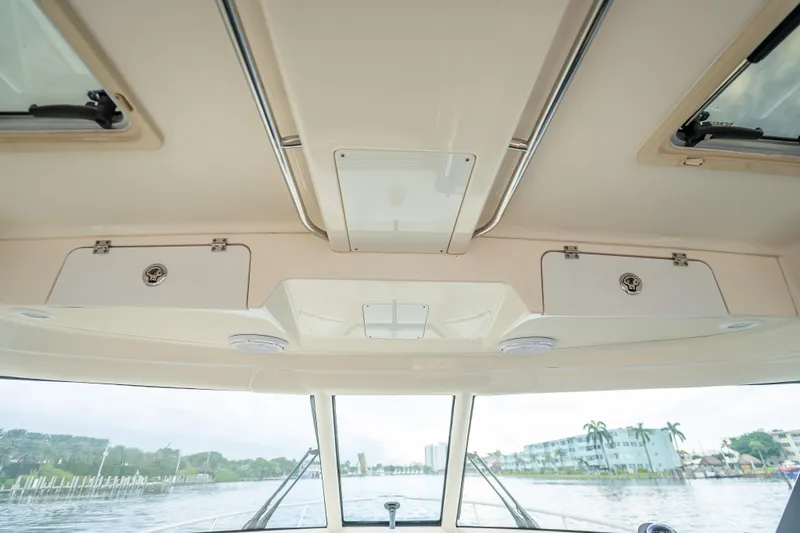 Slide: The Image of Interior view of 2011 Pursuit OS 345 Offshore boat, showcasing ceiling storage compartments. - 56