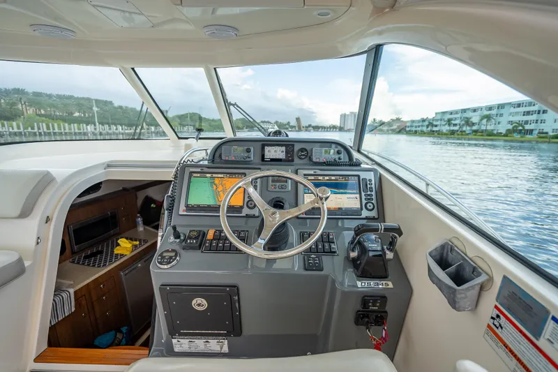 Slide: The Image of 2011 Pursuit OS 345 Offshore boat cockpit with navigation equipment and steering wheel. - 58