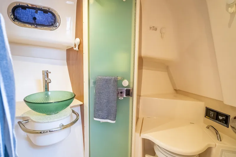 Slide: The Image of 2011 Pursuit OS 345 Offshore bathroom with glass sink and modern fixtures. - 66