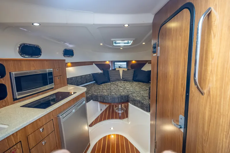 Slide: The Image of Interior of 2011 Pursuit OS 345 Offshore boat with kitchenette and cozy seating area. - 67