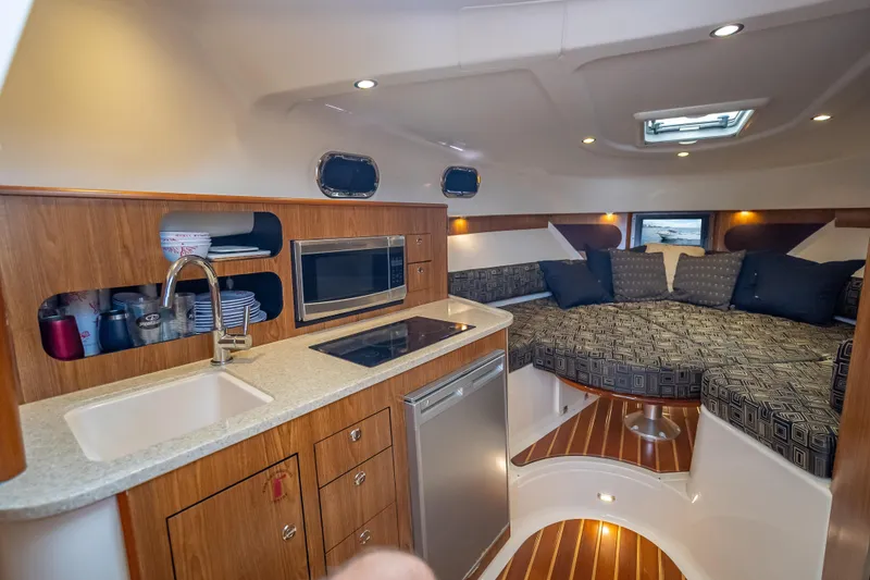 Slide: The Image of Luxurious interior of 2011 Pursuit OS 345 Offshore boat with kitchen and seating area. - 68
