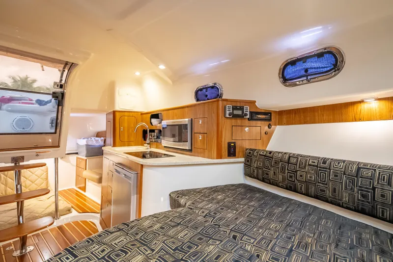 Slide: The Image of 2011 Pursuit OS 345 Offshore cabin interior with kitchenette, seating, and modern amenities. - 73