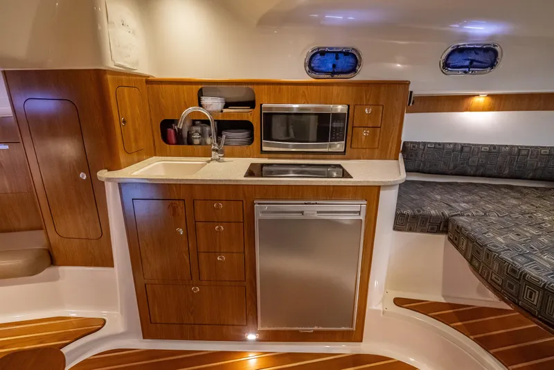 Slide: The Image of 2011 Pursuit OS 345 Offshore yacht interior with kitchenette and seating area. - 75