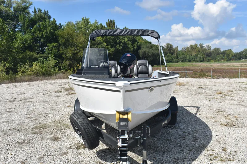 Slide: The Image of 2026 Lund 1800 Explorer SS boat on trailer, parked outdoors under blue sky. - 3