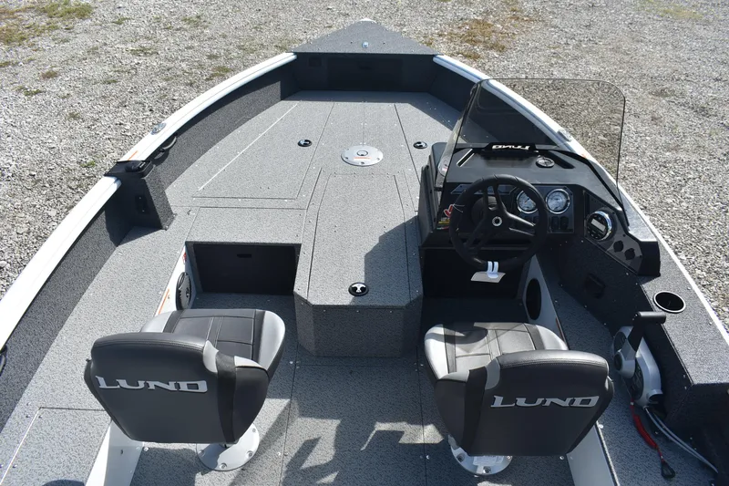 Slide: The Image of 2026 Lund 1800 Explorer SS boat interior with steering console and seating. - 9